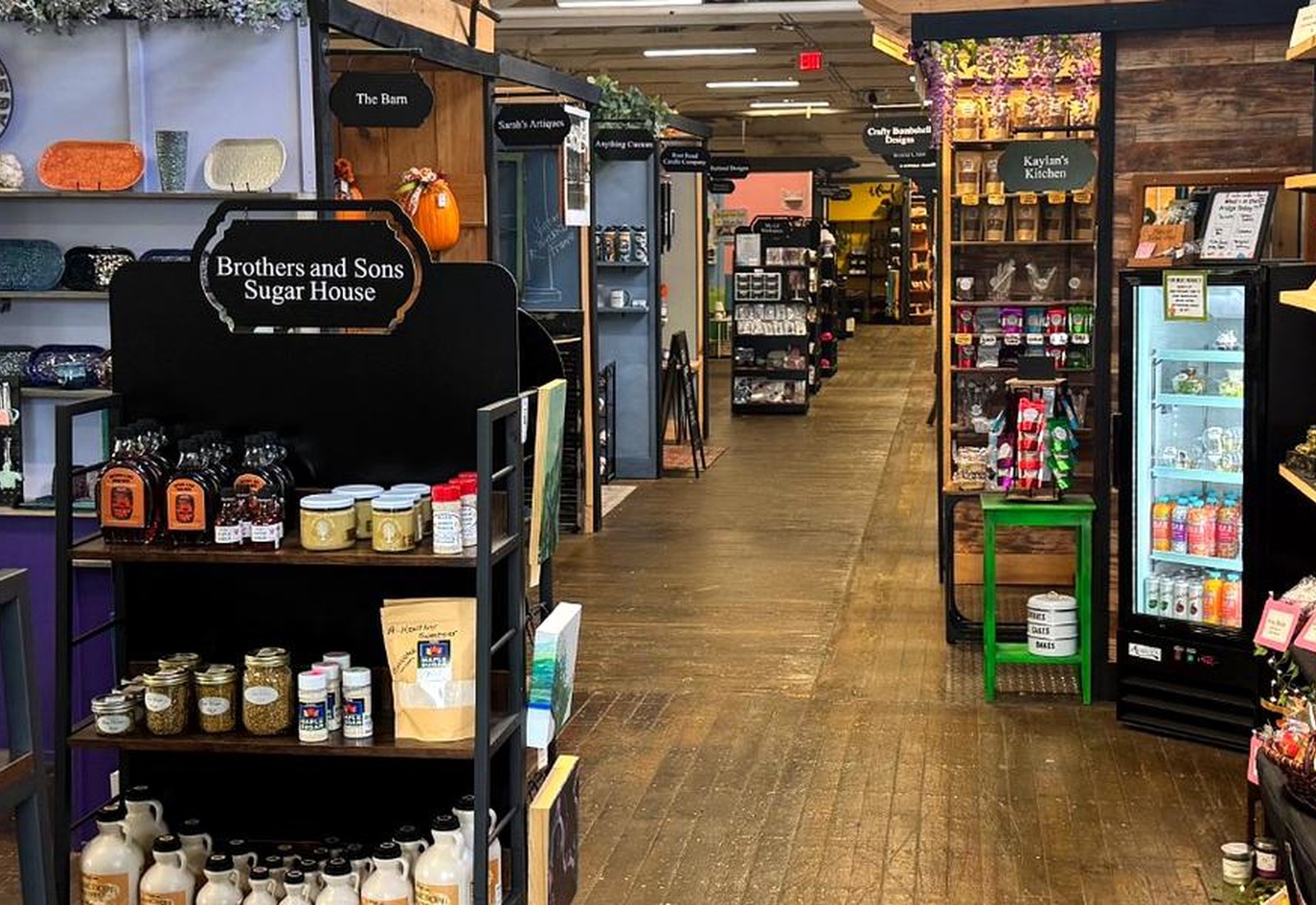 Aisle of vendor booths inside Market Street Creatives with signage and product displays